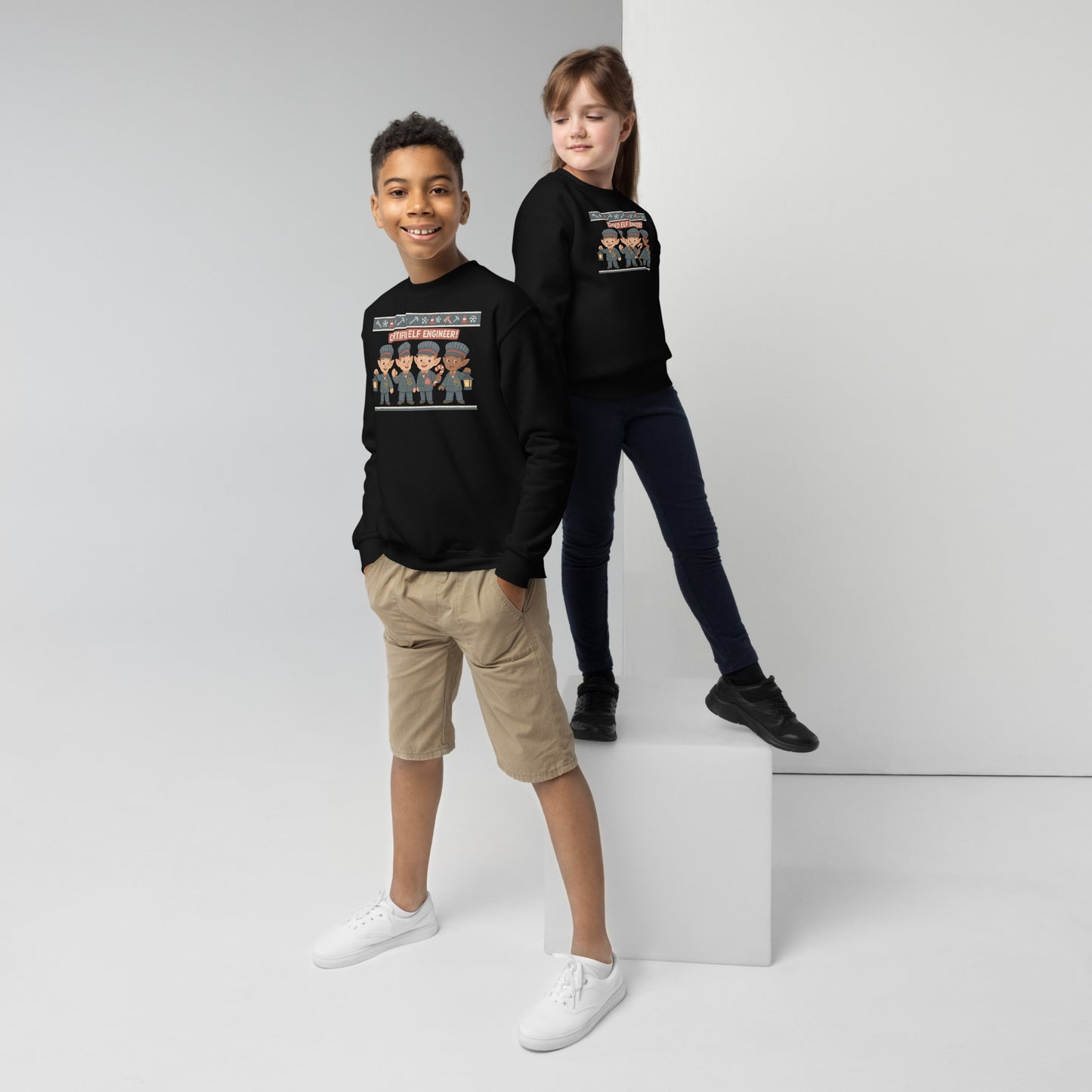 Two children wearing black sweatshirts with graphic designs on a white background