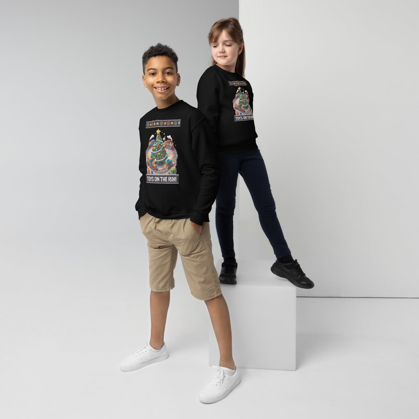 Two children wearing black sweatshirts with colorful graphics on a white background