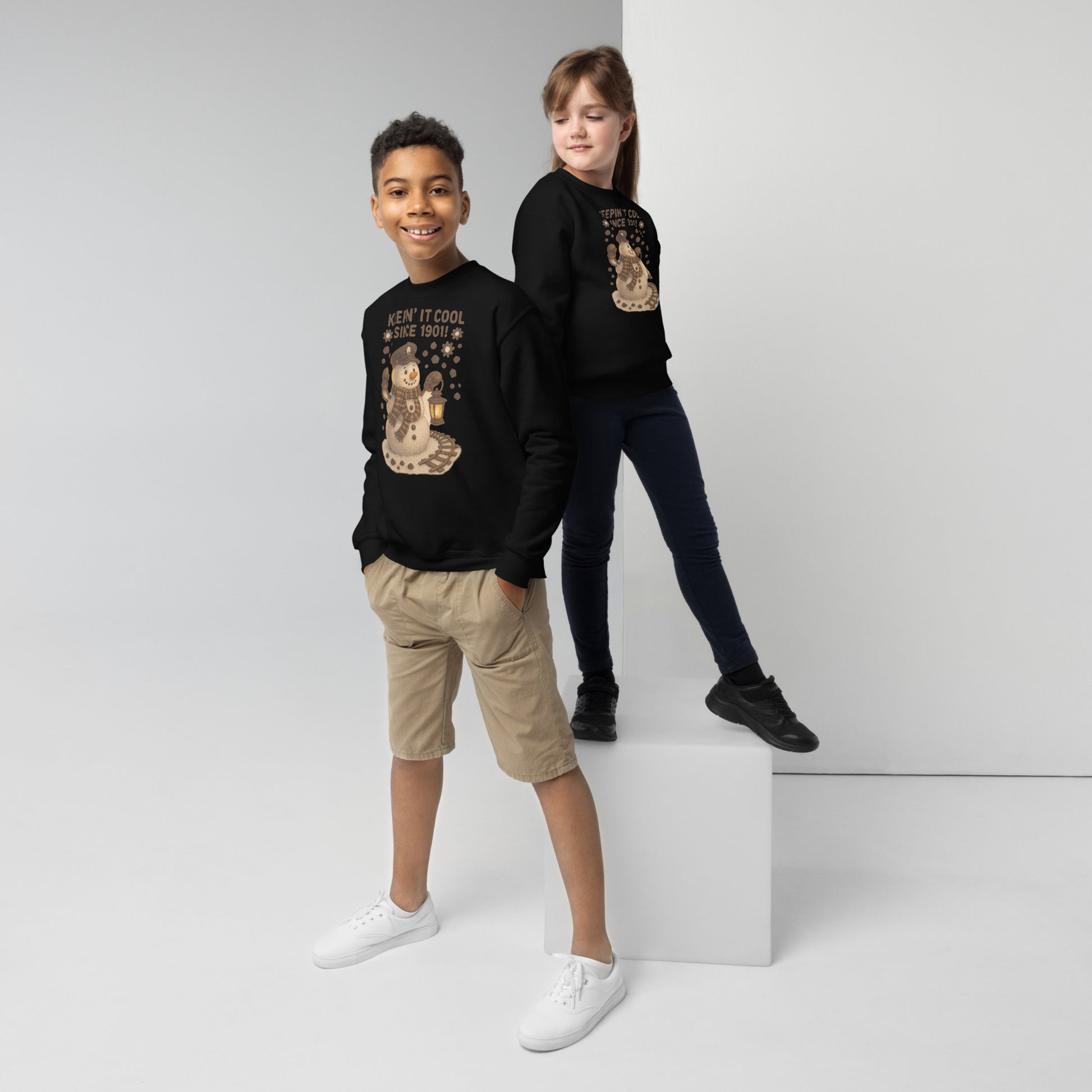 Two children wearing black sweatshirts with graphic designs on a white background