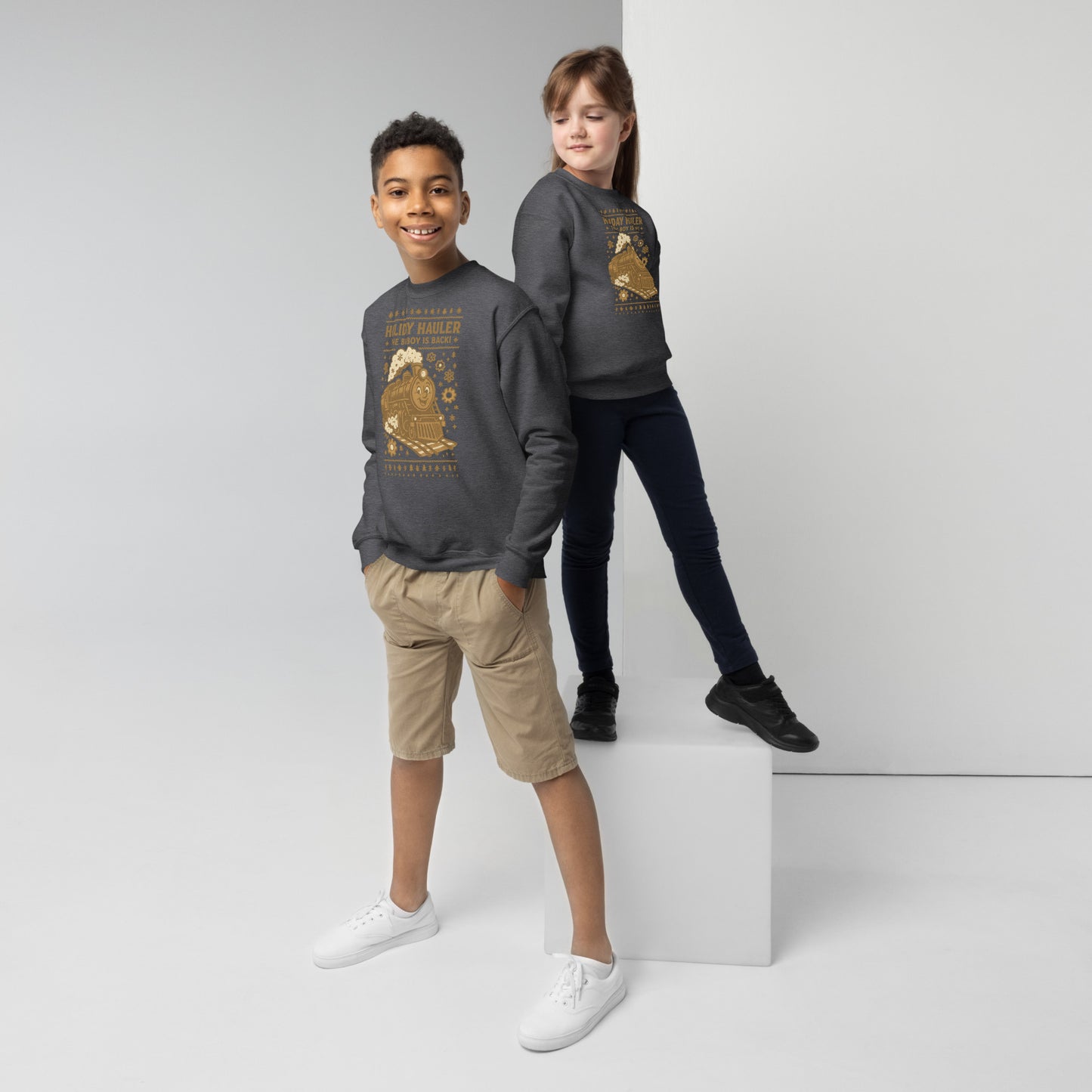 Two children wearing matching gray sweatshirts with a graphic design on a white background