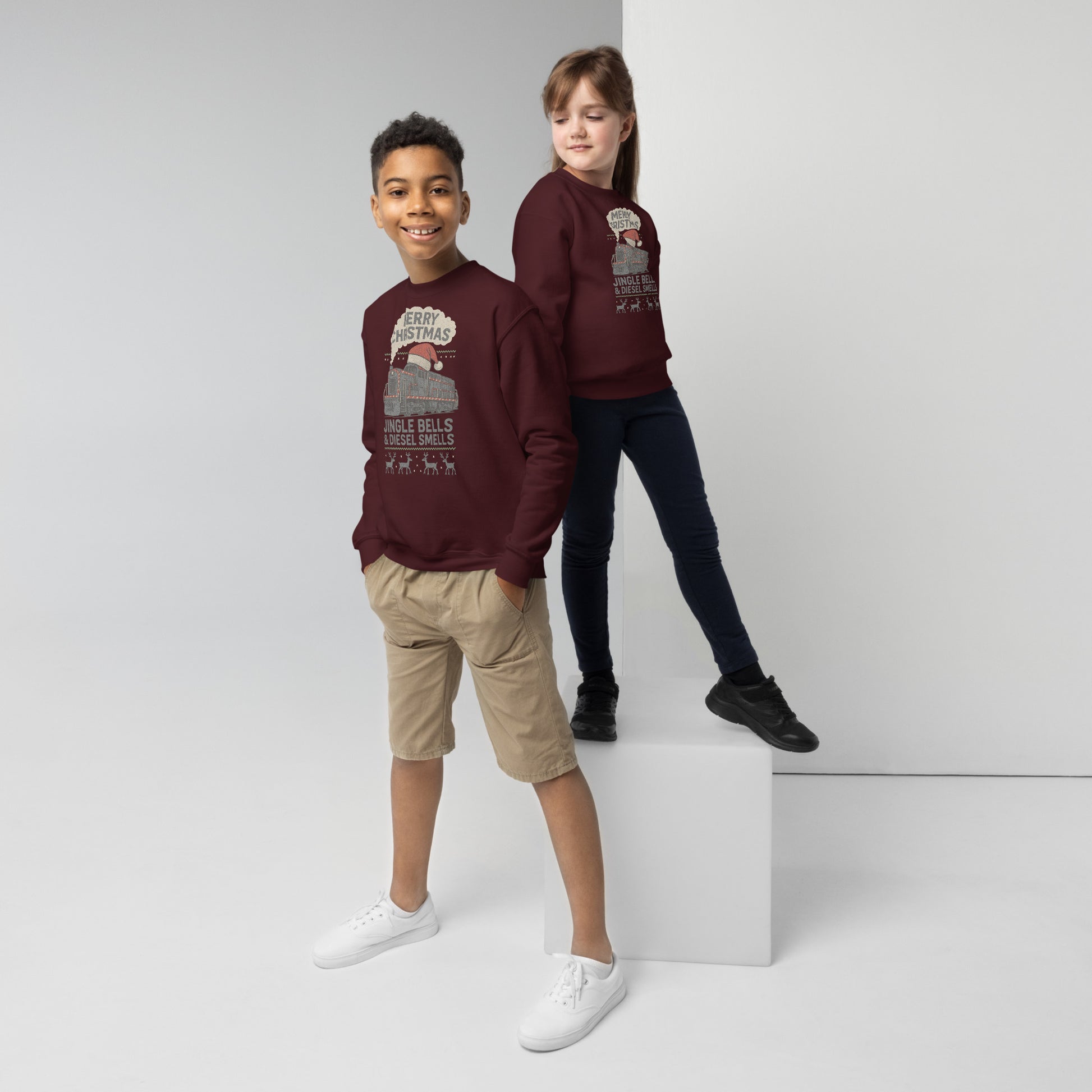 Two children wearing matching maroon sweatshirts on a white background