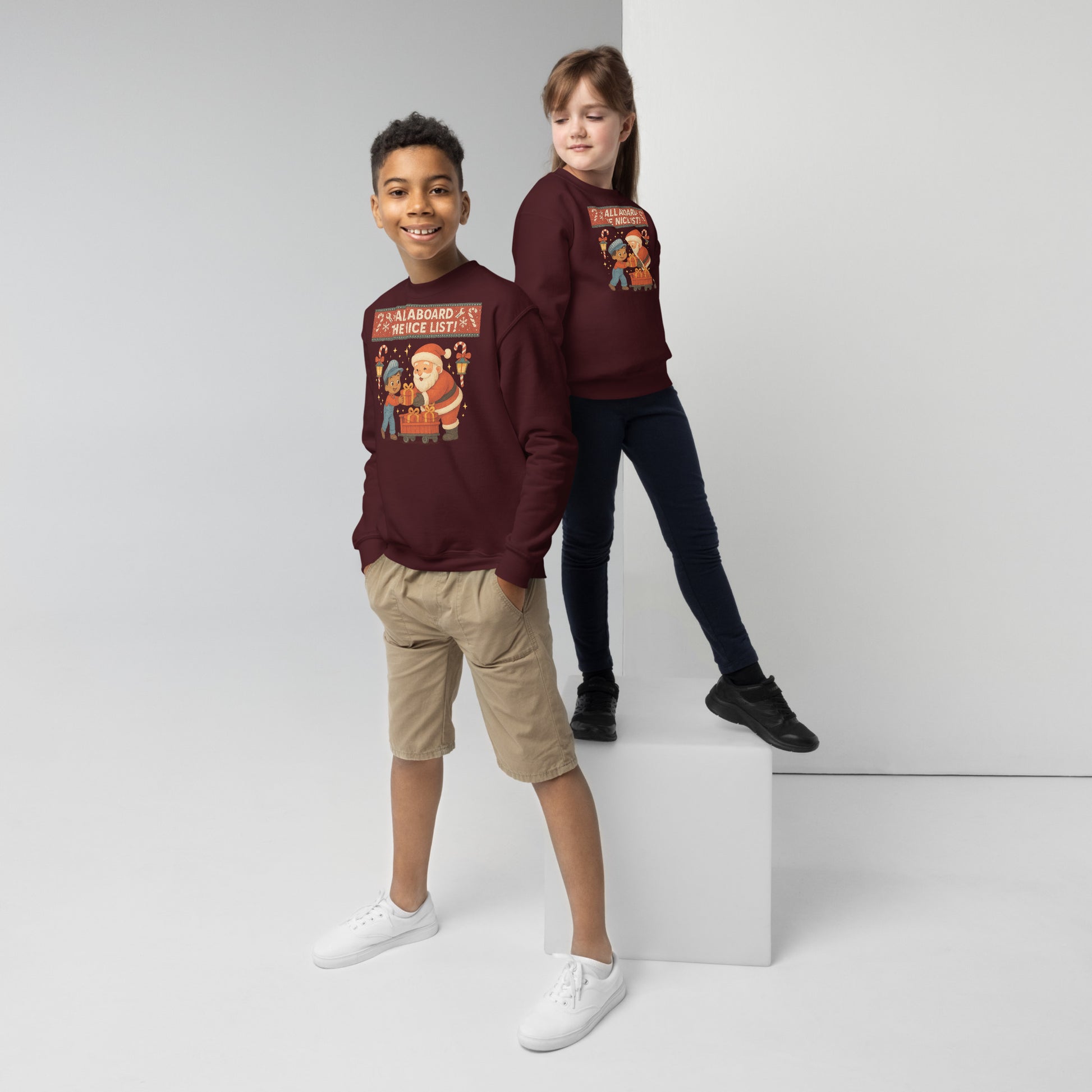 Two children wearing matching maroon sweatshirts with a graphic design on a white background