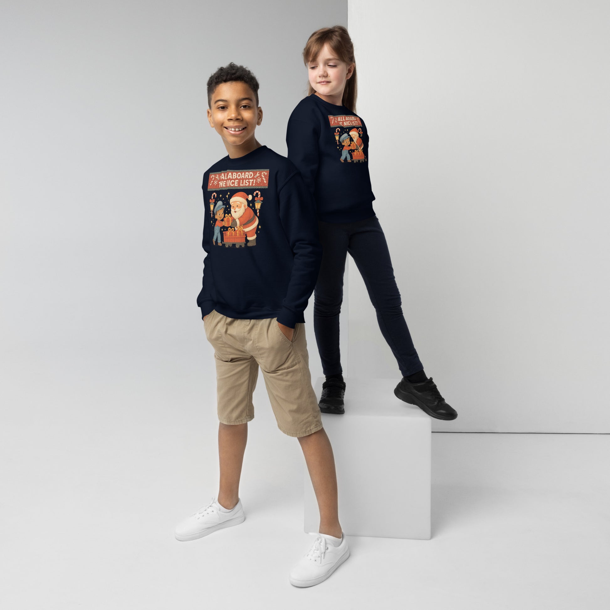 Two children wearing navy sweatshirts with graphic designs on a white background