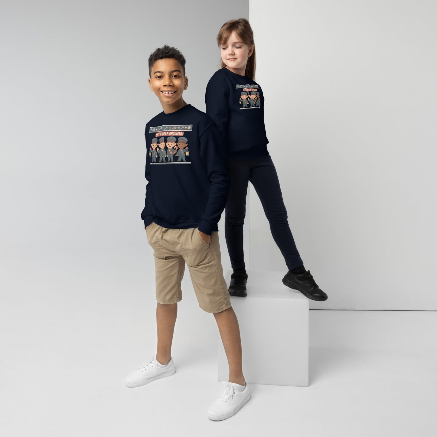 Two children wearing navy sweatshirts with graphic designs on a white background