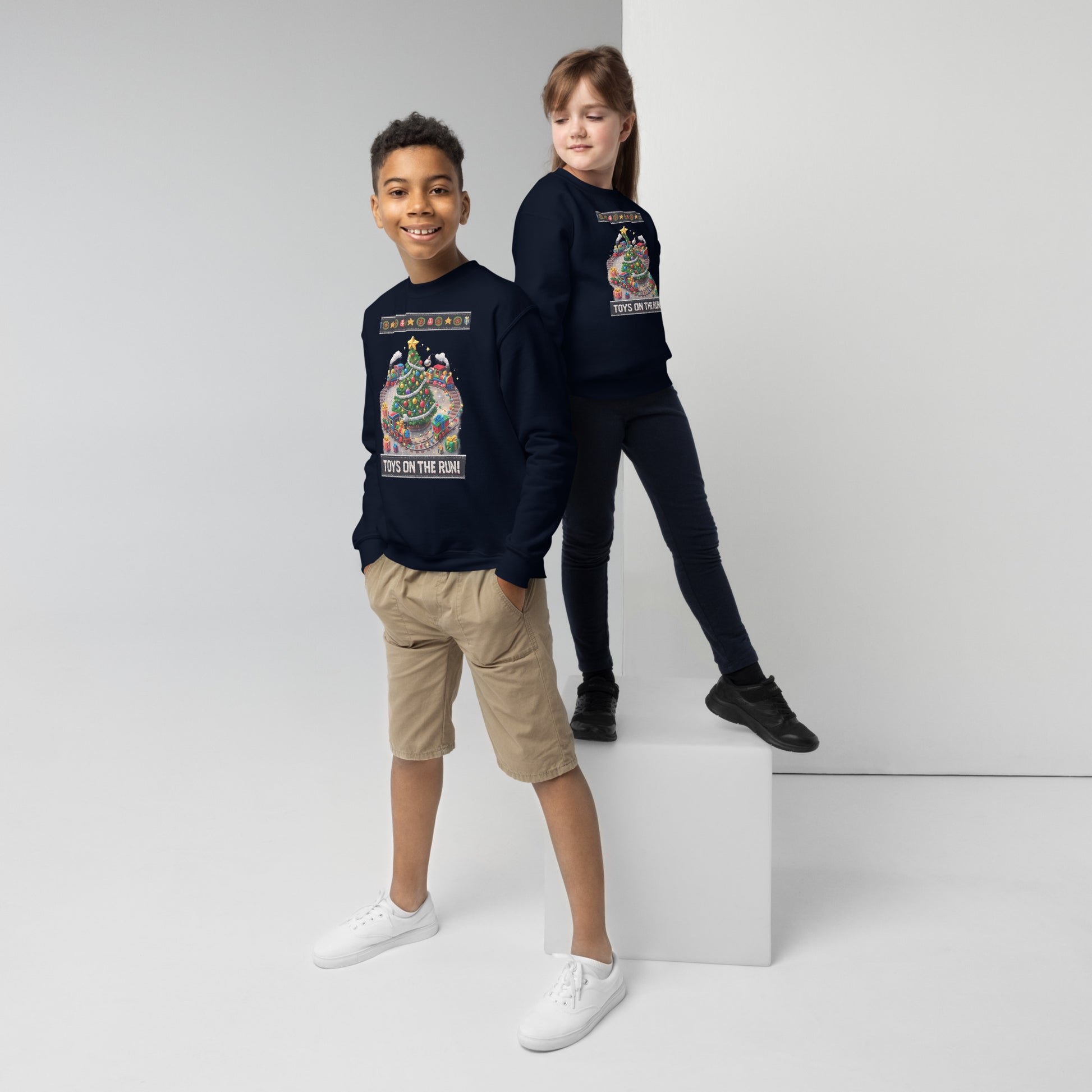Two children wearing navy blue sweatshirts with graphic designs on a white background