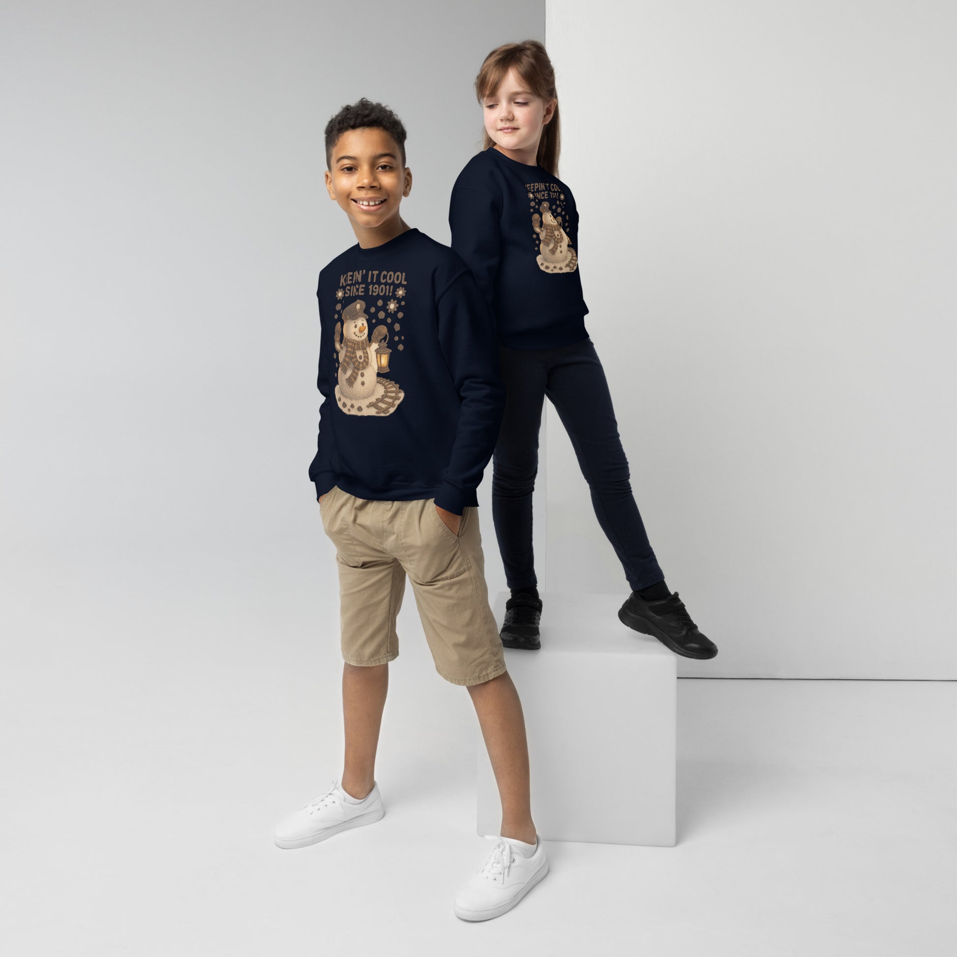 Two children wearing navy blue sweatshirts with graphic designs on a white background