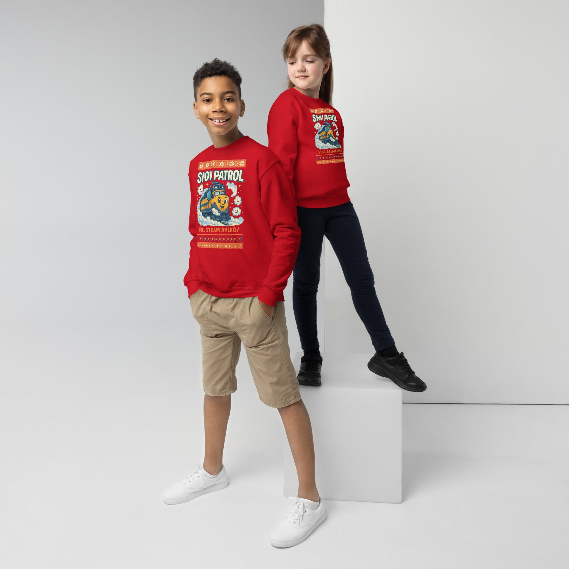 Two children wearing red 'Snow Patrol' sweatshirts on a white background