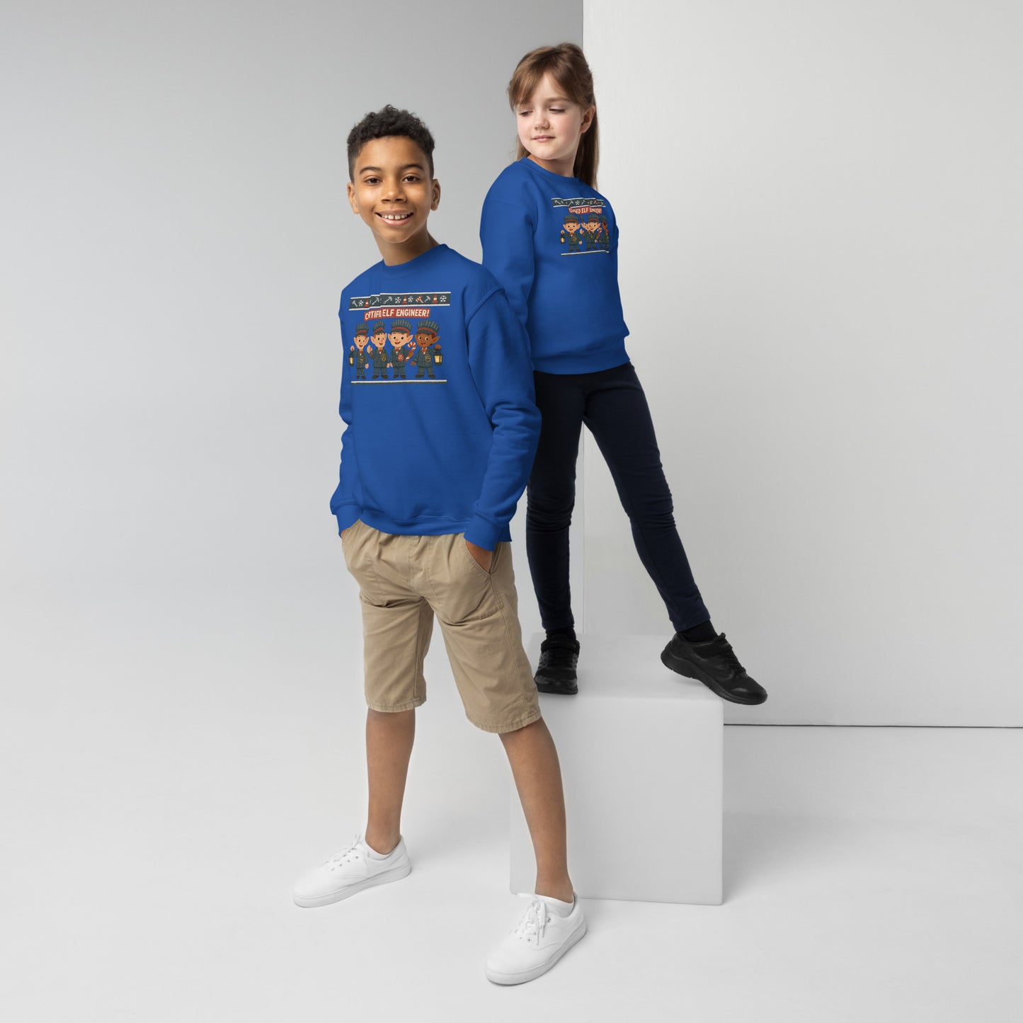 Two children wearing blue sweatshirts with a graphic design on a white background