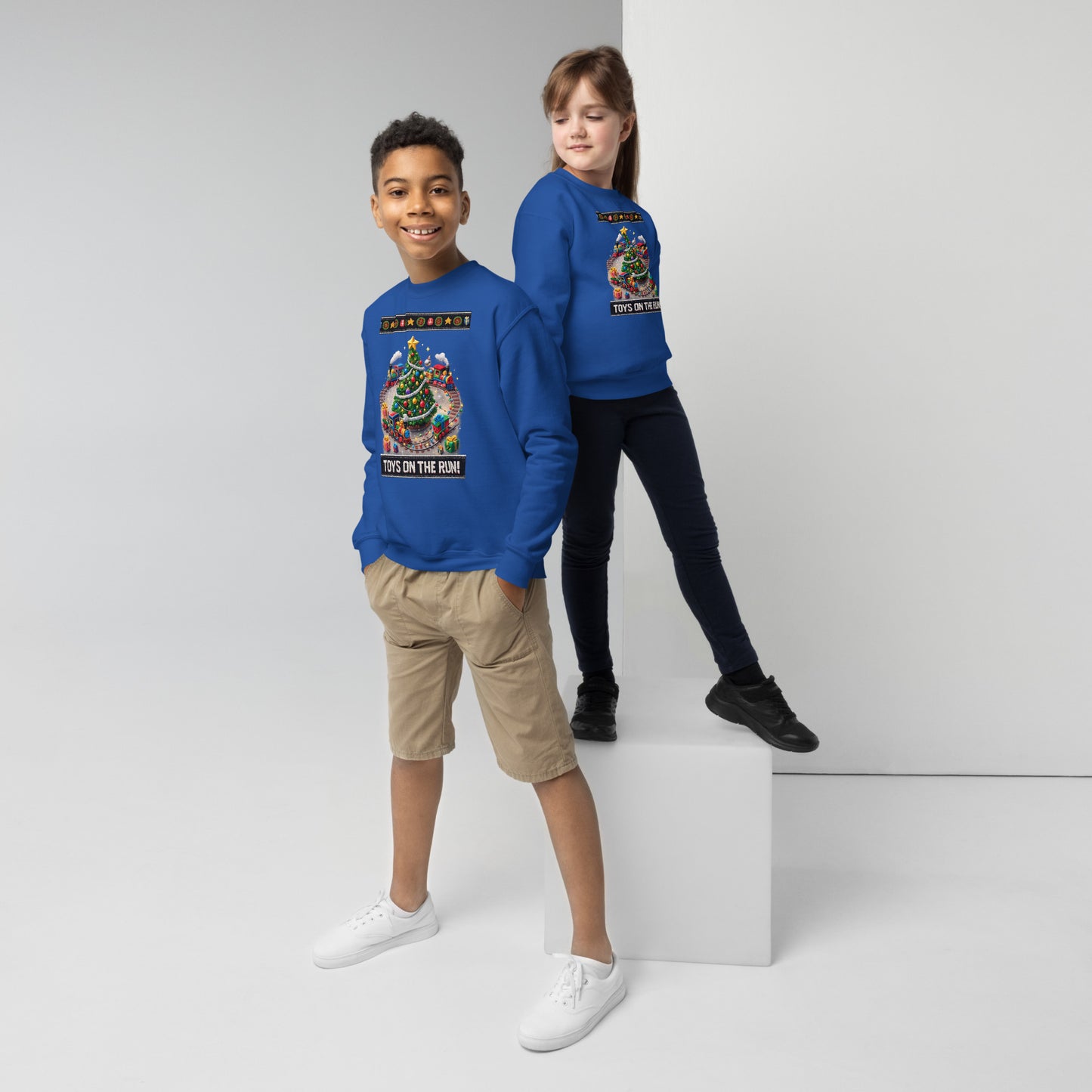 Two children wearing blue sweatshirts with colorful graphics on a white background
