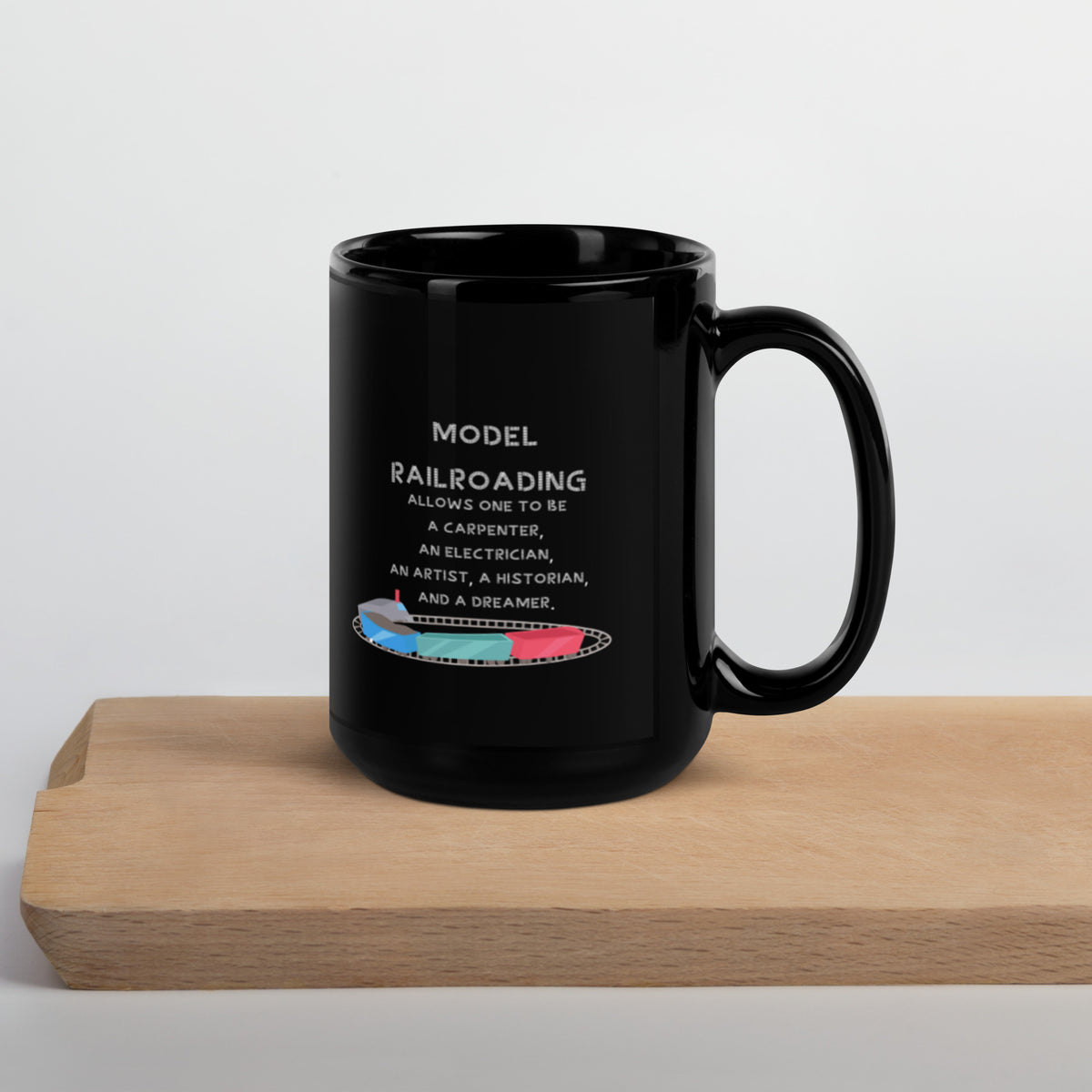 Glossy black 15 oz mug with Model Railroading quote text on a wooden board, handle right